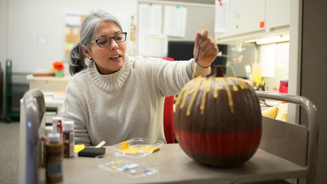 Woman painting a pumpkin