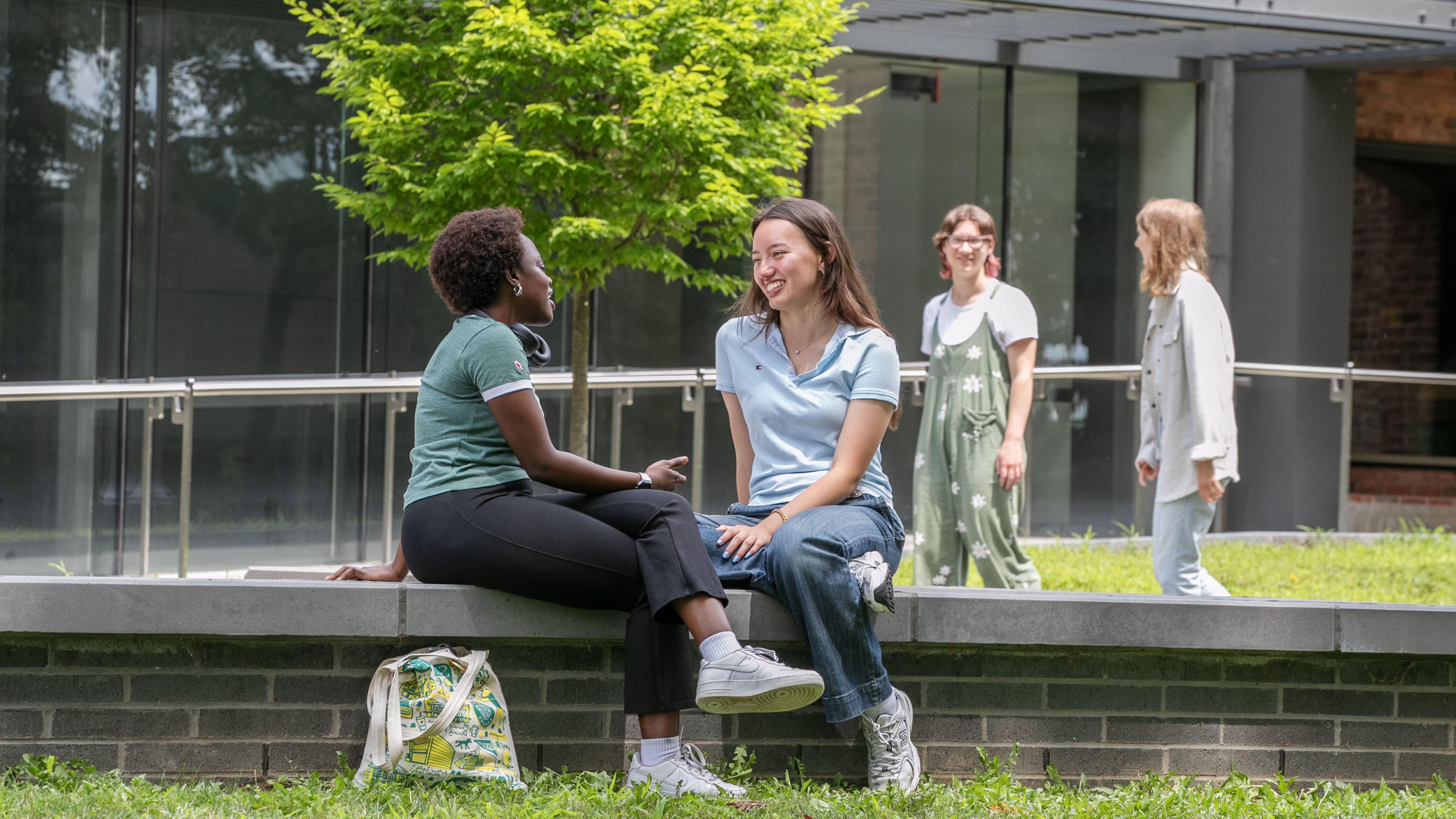 Two students chat outside of the Billie Tisch Center for Integrated Sciences.